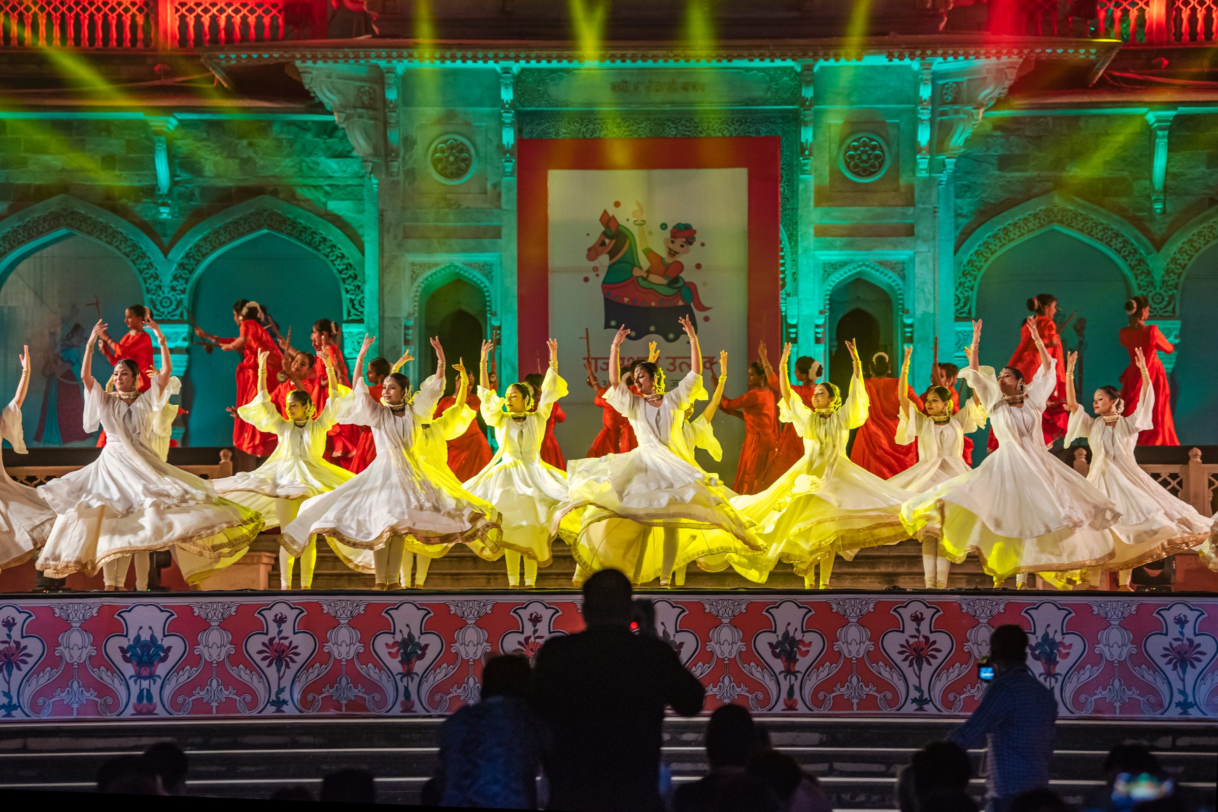 Dancers mid-turn under green and red stage light