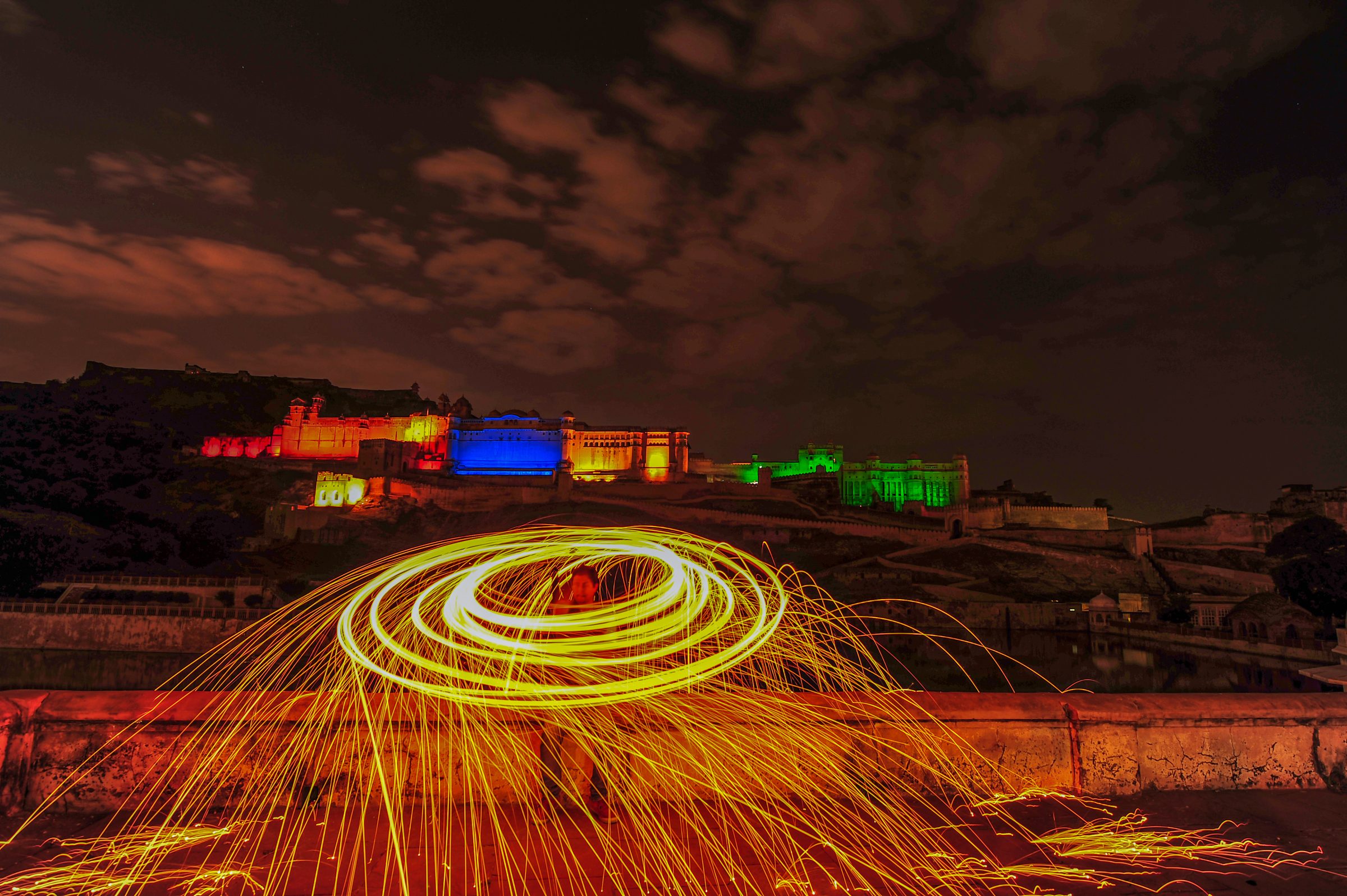 A spiral of sparks in front of a floodlit fort