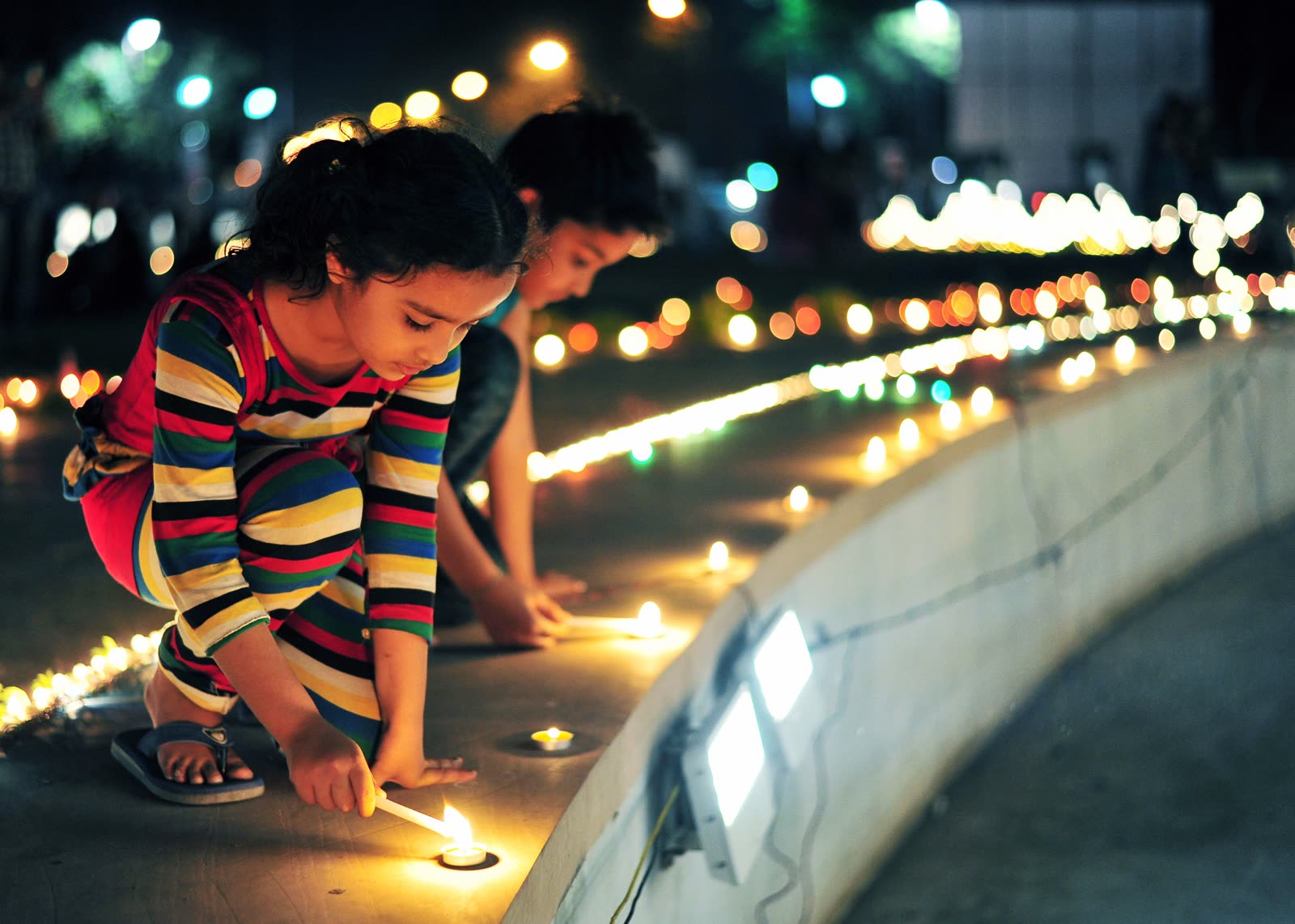 Children lighting candles at night